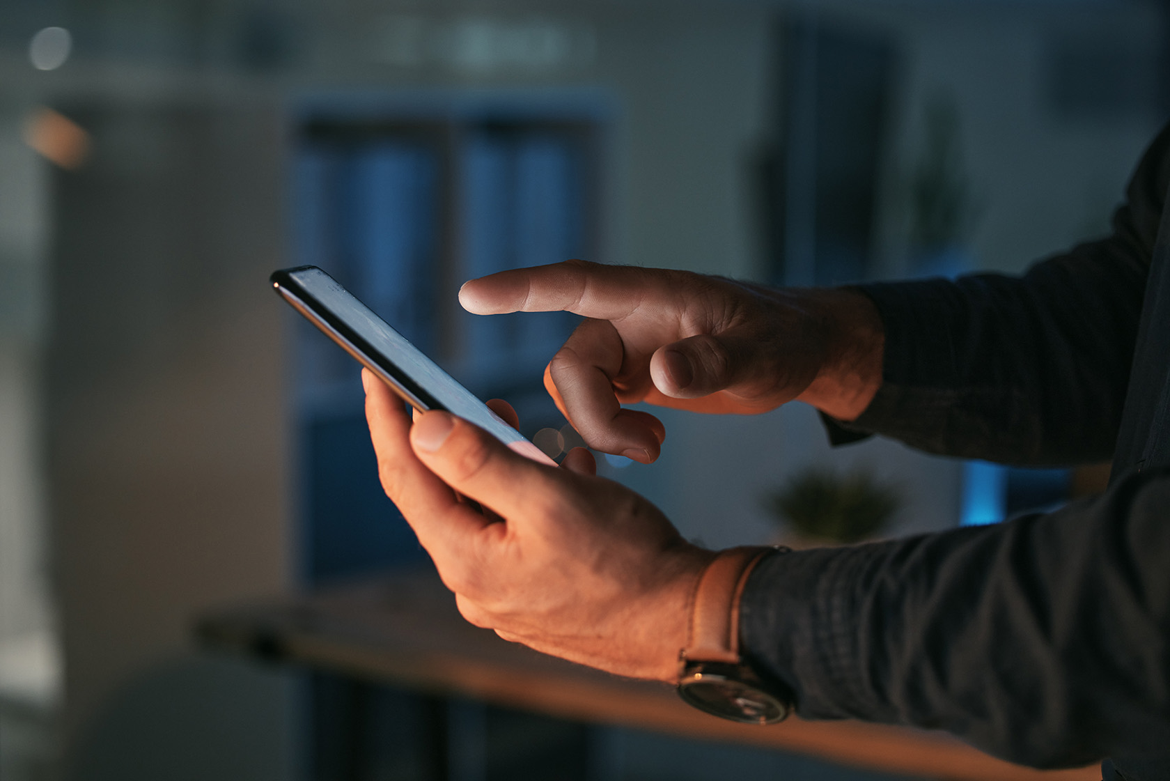 Hands of man holding phone and typing on it